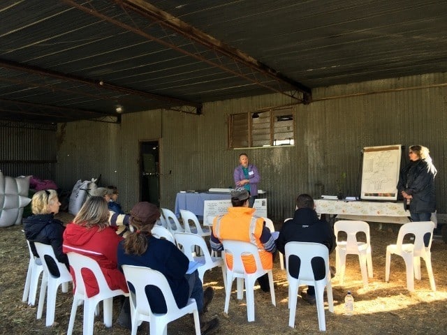 people sitting in barn at talk