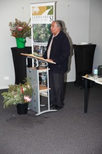George Walley standing at lectern speaking