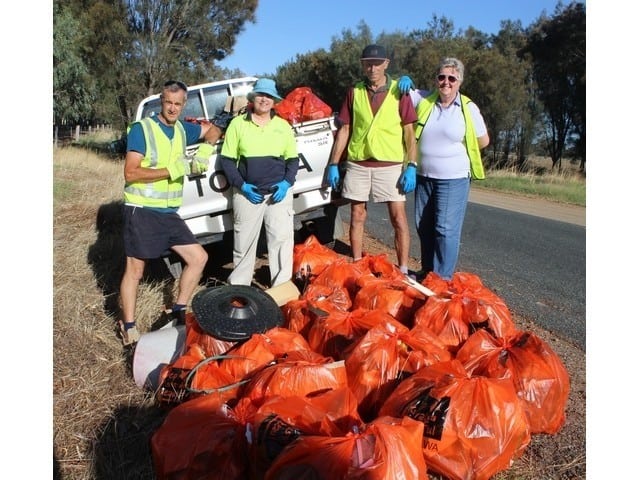 People standing next to bags of garbage collected on Clean Up Australia Day