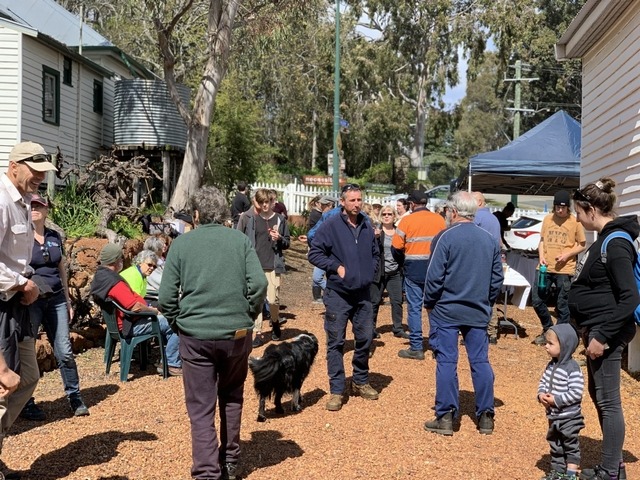 people at event in bush setting with old buidings